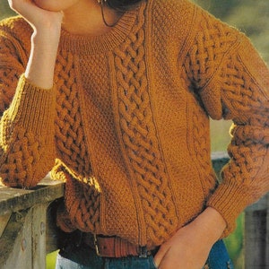 May include: A brown cable knit sweater with a round neckline. The sweater has a textured pattern and is made of a soft, warm material.