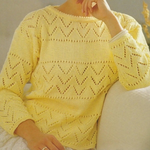 May include: A yellow knitted sweater with a chevron pattern and openwork design.