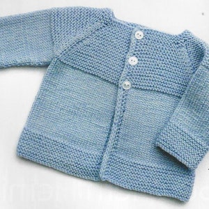 May include: A light blue knitted baby cardigan with a button fastening. The cardigan has a simple design with a ribbed collar and cuffs.
