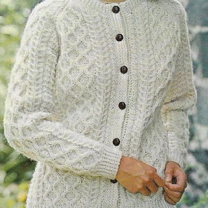 May include: A white knitted cardigan with a cable knit pattern and button closure.