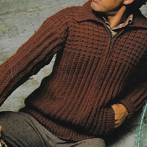 Op de afbeelding: Een bruin gebreid vest met een ritssluiting en een geribbelde textuur. Het vest heeft een kraag en lange mouwen.