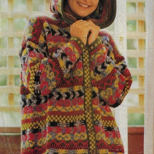 May include: A colourful knitted cardigan with a hood, featuring a geometric pattern in shades of red, yellow, green, and black. The cardigan has a button closure and is made of a soft, textured yarn.