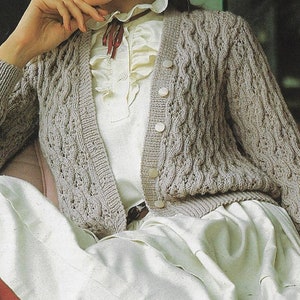 May include: A light brown cable knit cardigan with a button front and long sleeves.