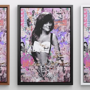 May include: A framed print of a woman with dark hair and a white crop top, standing in front of a pink and purple graffiti wall. The wall is covered in colorful posters and text.