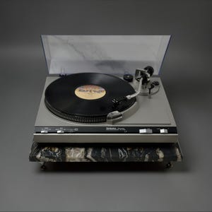 May include: A white ceramic mug with a black handle and the text "But First, Coffee" in a black, bold font. The mug is on a white surface.