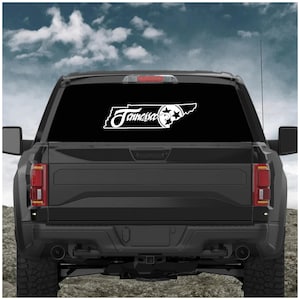 May include: White decal featuring the outline of Tennessee with the word "Tennessee" in a cursive font. The decal also includes a star and a stylized image of a basketball. The decal is displayed on the rear window of a black truck.
