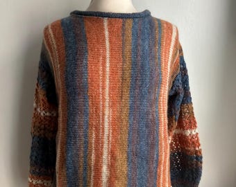 Suéter tipo túnica de mohair tejido a mano, con rayas degradadas en azul y naranja, y mangas de encaje.
