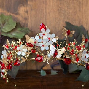 A delicate tiara adorned with blooming flowers and graceful butterflies, symbolizing transformation, beauty, and new beginnings. Designed with soft floral details and fluttering butterfly accents, this enchanting tiara adds a magical fairy-tale touch to any special moment.
Gold colored tiara with sparkles stones accents and small crystal rhinestones. 
Perfect for enchanted forest quinceañera, garden weddings, photo shoots, festivals, queen or princess, proms, birthdays, or any other occasion.