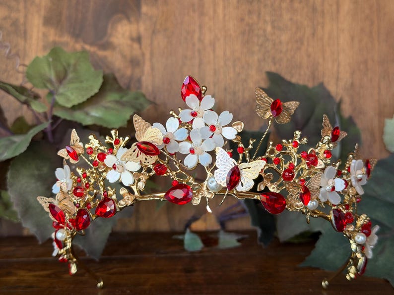A delicate tiara adorned with blooming flowers and graceful butterflies, symbolizing transformation, beauty, and new beginnings. Designed with soft floral details and fluttering butterfly accents, this enchanting tiara adds a magical fairy-tale touch to any special moment.
Gold colored tiara with sparkles stones accents and small crystal rhinestones. 
Perfect for enchanted forest quinceañera, garden weddings, photo shoots, festivals, queen or princess, proms, birthdays, or any other occasion.