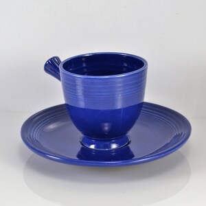May include: A blue ceramic teacup and saucer set. The cup has a unique handle and the saucer has a ridged design.