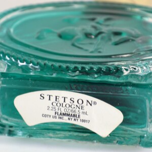 以下が含まれることがあります： 白いラベルに「STETSON&reg; COLOGNE 2.25 FL OZ/66.5 mL FLAMMABLE COTY US INC., NY NY 10017」と書いてある、ターコイズブルーのガラス瓶。