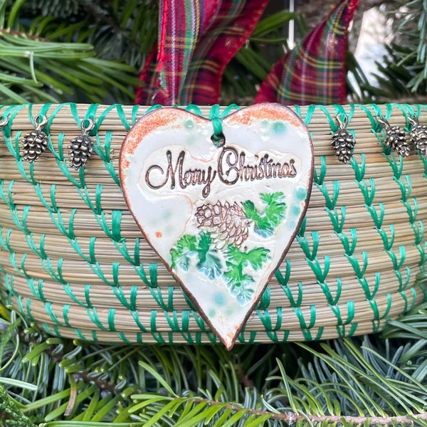 Lovely pine needle basket with a "Merry Christmas" pottery heart pendant and petrified wood center entitled "Woodland Christmas".