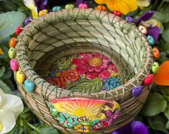 Cool "Flower Child" pine needle and sweetgrass basket with colorful heart and flower beads and a multicolored flower clay and wood base.
