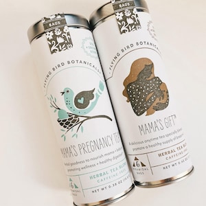 May include: Two metal tins of Flying Bird Botanicals herbal tea. The tin on the left is labeled "Mama's Pregnancy Tea" with a blue bird illustration. The tin on the right is labeled "Mama's Gift" with a brown illustration of a woman breastfeeding. Both tins have a green and brown floral design and are labeled with "6 Pyramidal Bags".