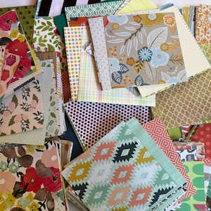 May include: A large collection of square paper sheets featuring a diverse array of patterns including floral prints, geometric shapes, polka dots, stripes, and damask designs in a wide variety of colors such as red, blue, green, yellow, and brown.