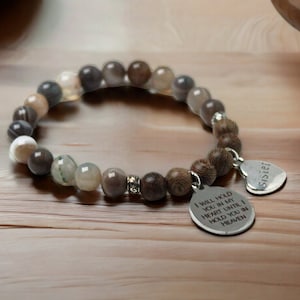 May include: A brown and gray beaded bracelet with a silver charm that reads "I will hold you in my heart until I hold you in heaven" and a heart charm that reads "Sister".