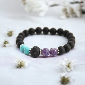May include: A black beaded bracelet with turquoise, lava rock, and amethyst beads.