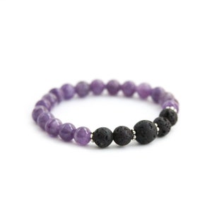 May include: A purple amethyst and black lava rock beaded bracelet. The bracelet is made with small round beads and has a simple design.