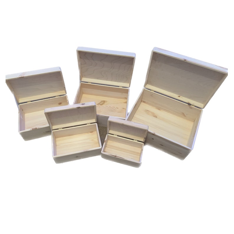 May include: Five wooden boxes of varying sizes with lids open. The boxes are made of unfinished light wood and are all rectangular in shape.