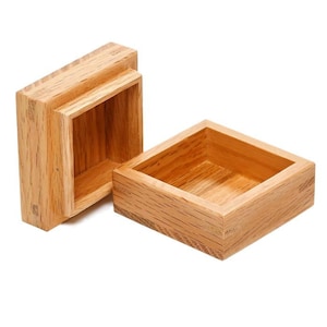 May include: A wooden box with a hinged lid, open to reveal the empty interior. The box is made of light brown wood with a natural grain pattern.