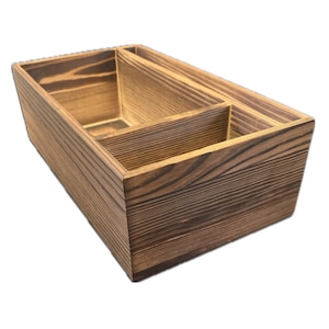 May include: A wooden organiser with three compartments, stained dark brown to highlight the wood grain. The rectangular shape and internal dividers create storage space. Ideal for organising items in a home or office setting. Measures approximately 25 cm in length.