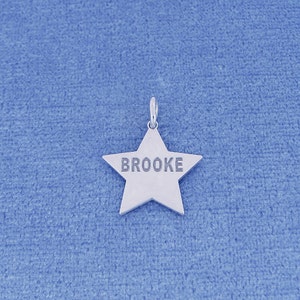 May include: Silver star charm with the name "Brooke" engraved on it.