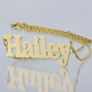 May include: Gold necklace with a nameplate pendant that reads "Hailey".