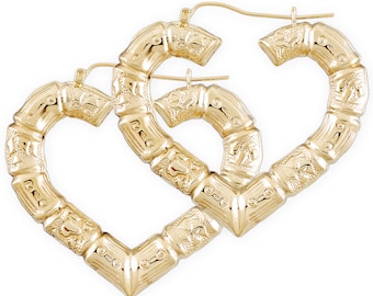 May include: A pair of gold-colored heart-shaped hoop earrings. The earrings have a bamboo-style design with intricate detailing. The earrings are displayed against a white background.