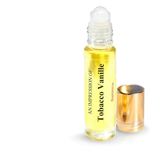 May include: A clear glass roll-on bottle with a gold cap filled with a yellow liquid. The bottle label reads "An Impression of Tobacco Vanille" with the brand name "Soprano" in red text.