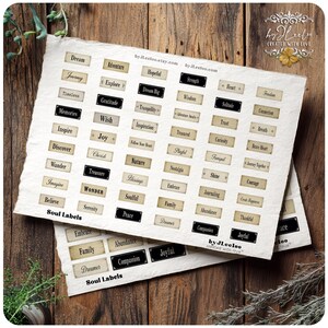 May include: Two sheets of paper with various rectangular labels printed on them. The labels feature words like "Dream," "Joy," and "Wonder." The paper has a rustic, aged appearance, with the text in a variety of fonts. The words "Soul Labels" are printed at the bottom.