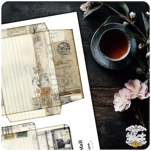 May include: A vintage-style paper envelope with aged paper and handwritten script. The envelope is open, revealing the interior with lined paper. A cup of tea and pink flowers are on a dark wood surface.