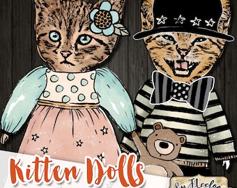 Könnte beinhalten: Zwei bedruckbare Papierpuppen von Kätzchen, eine trägt ein blaues Kleid mit weißen Punkten und eine Blume im Haar, die andere trägt einen schwarz-weiß gestreiften Pullover mit einer schwarzen Schleife und einen schwarzen Hut mit weißen Sternen. Der Text "Kitten Dolls" steht in großen orangefarbenen Buchstaben am unteren Rand des Bildes.