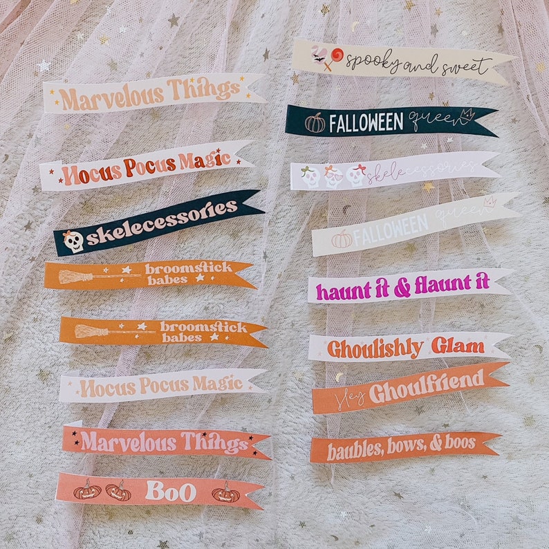 Puede incluir: Un conjunto de 12 pancartas imprimibles con tem&aacute;tica de Halloween con varios lemas espeluznantes y lindos. Las pancartas son de varios colores, incluidos el rosa, el naranja, el negro y el blanco. El texto en las pancartas incluye frases como "spooky and sweet", "haunt it & flaunt it", "broomstick babes" y "ghoulishly glam".