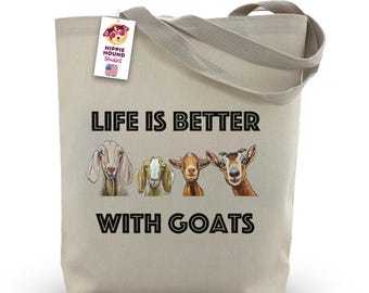 May include: A beige canvas tote bag featuring the text "LIFE IS BETTER WITH GOATS" and illustrations of four goats. The bag has a tag that says "Hippie Hound Studios" and "Made in the USA".