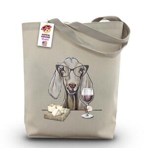 Può includere: Borsa tote in tela beige con un'illustrazione umoristica di una capra con gli occhiali, che tiene in mano un bicchiere di vino e con un tagliere di formaggi. La borsa ha un'etichetta con "Hippie Hound Studios" e "USA".