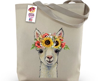 May include: A beige canvas tote bag featuring a white llama wearing a flower crown. The crown is made of sunflowers, red poppies, and white flowers. The bag has a tag that says "Hippie Hound Studios" with a small American flag.