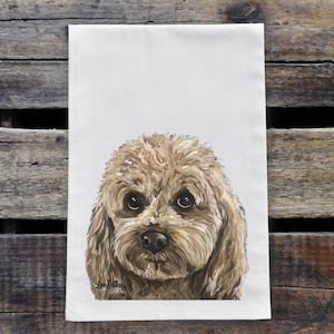 May include: A hand-painted tea towel featuring a close-up portrait of a light brown dog with curly fur. The dog has a sweet expression with big brown eyes and a wet nose.