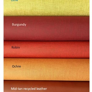 May include: Five horizontal rolls of material stacked vertically. The colors are labeled as Lime, Burgundy, Robin, Ochre, and Mid-tan recycled leather. Each roll displays a distinct texture and solid color, ranging from yellow-green to deep red and brown.