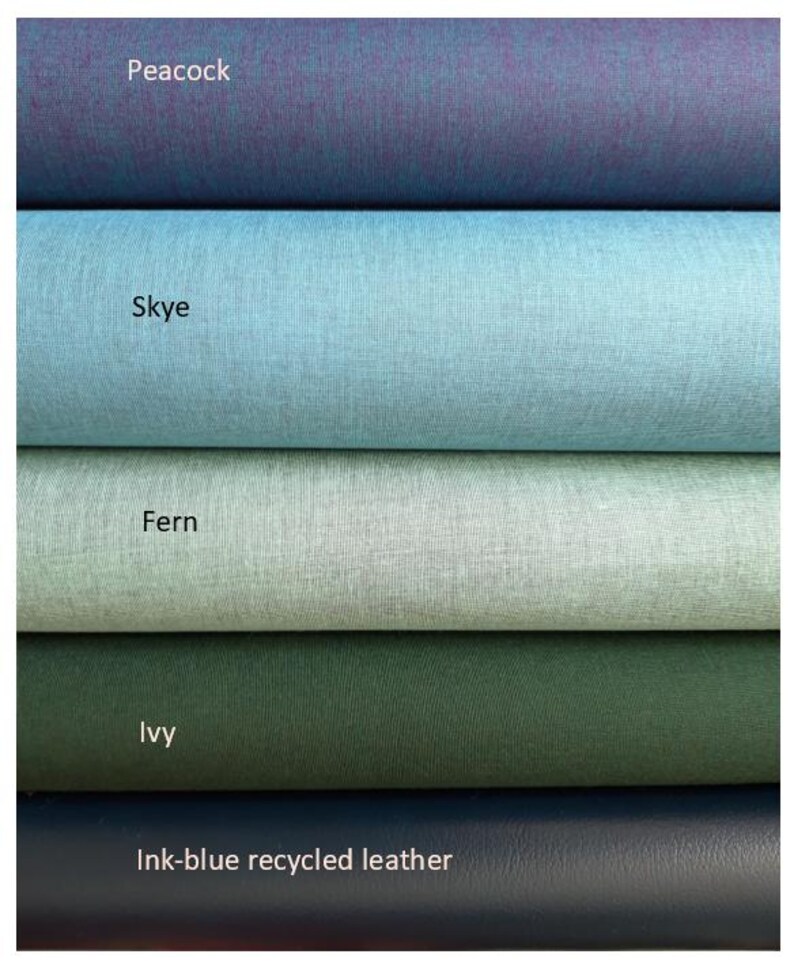 May include: Five stacked rolls of material featuring distinct colors and textures. The top roll is labeled Peacock, followed by Skye, Fern, and Ivy, all showing a fine-grained surface. The bottom roll is labeled Ink-blue recycled leather.