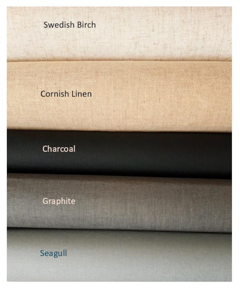 May include: Five stacked rolls of fabric in varying neutral tones. The top roll is labeled Swedish Birch, followed by Cornish Linen, Charcoal, Graphite, and Seagull. Each roll displays a distinct texture and color, ranging from off-white to light gray.