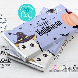 May include: A Halloween-themed chocolate bar wrapper with a light purple background, featuring a cartoon ghost wearing a witch hat. The wrapper includes the text "happy Halloween", bats, stars, a pumpkin, and a spiderweb.