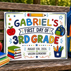 May include: A rectangular sign with a white background featuring colorful illustrations of a pencil, apple, backpack, books, and school supplies. The text reads: GABRIEL'S FIRST DAY OF 3RD GRADE, AUGUST 5TH, 2026, and WILSON ELEMENTARY in various fonts.