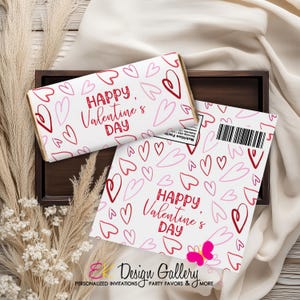Pode incluir: Duas embalagens de barras de chocolate e um cartão com tema de Dia dos Namorados com um padrão de corações. As embalagens e o cartão têm o texto "Happy Valentine's Day" em vermelho. O cartão tem um gráfico de borboleta rosa e um código de barras.