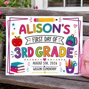 May include: A rectangular white sign with colorful text and graphics. It reads ALISON'S FIRST DAY OF 3RD GRADE, AUGUST 5TH, 2026, and WILSON ELEMENTARY. Features include a yellow pencil, a red apple, a blue backpack, books, and school supplies.