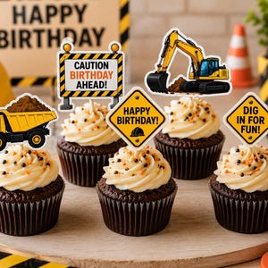 May include: Five chocolate cupcakes with white frosting and orange and black sprinkles, each topped with a construction-themed paper topper featuring a yellow dump truck, an excavator, or signs reading CAUTION BIRTHDAY AHEAD, HAPPY BIRTHDAY, or DIG IN FOR FUN.