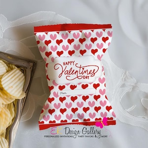 May include: A Valentine's Day themed snack bag with a red and white heart pattern. The bag has a red top and bottom border. The words "Happy Valentines Day" are written in a decorative font. There is a space to write "From".