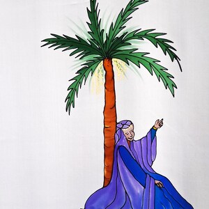 May include: A white fabric panel featuring a hand-painted illustration of a palm tree with a brown trunk and green fronds. A figure wearing a long purple and blue robe sits at the base of the tree, pointing upward. A signature is visible on the left.