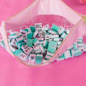 a pink table with a pink and white table cloth and a pink purse filled with