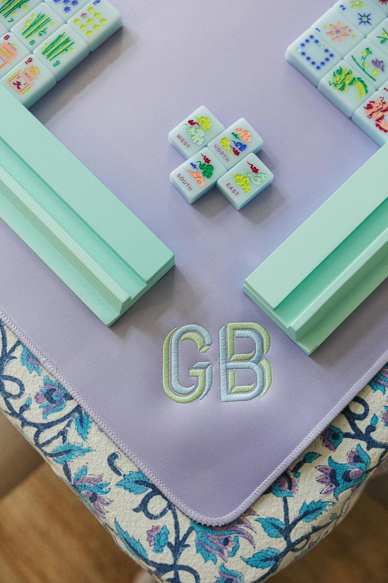 a collection of colorful tiles and a purple mat with the initials "GB" embroidered on it.
