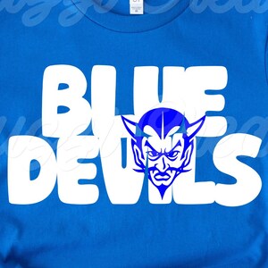 May include: Royal blue t-shirt with the words "BLUE DEVILS" in large white letters. A blue devil mascot graphic is centered between the words. The shirt is made of a soft material and is likely a fan item.